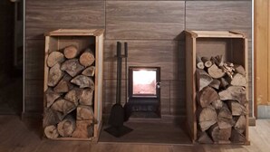 Une cheminée moderne dotée d’un espace de rangement pour le bois de chauffage de chaque côté.