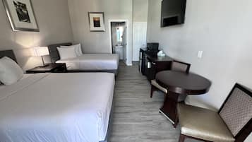 Een hotelkamer met twee bedden, een bureau, een televisie en een zithoek.