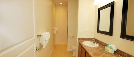 A bathroom with two sinks, a toilet, and a shower.