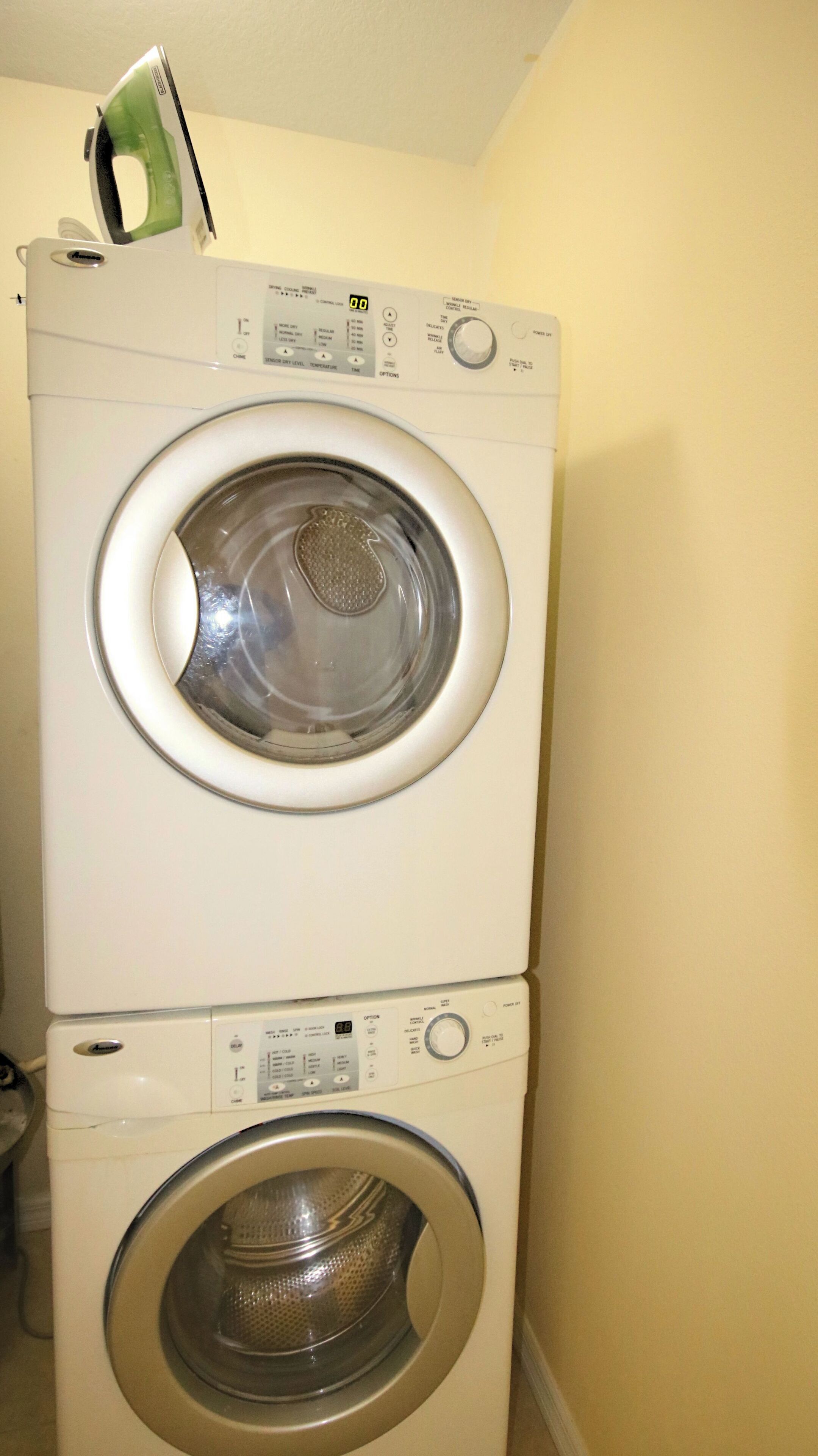 A stacked washer and dryer unit in a laundry room.