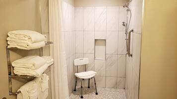 Ein kleines, modernes Badezimmer mit Dusche, Toilette und Handtuchhalter.