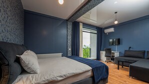 A modern hotel room with a large bed, a sofa, a desk, and a TV. - Hotel Villa Lapa (Telavi)