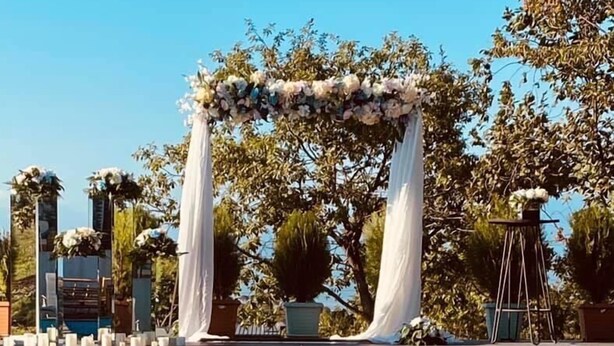 A pool with clear blue water, surrounded by white drapes and floral arrangements. - Hotel Villa Lapa (Telavi)