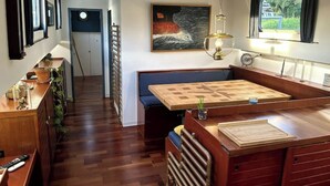 A compact kitchen with a wooden countertop, a bench seating area, and a view through a window. - Au fil de Leau (Plobsheim)