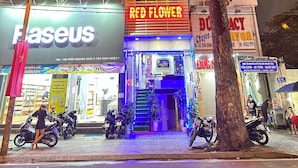 Un edificio de varios pisos con un llamativo letrero que dice 'HOTEL RED FLOWER'.