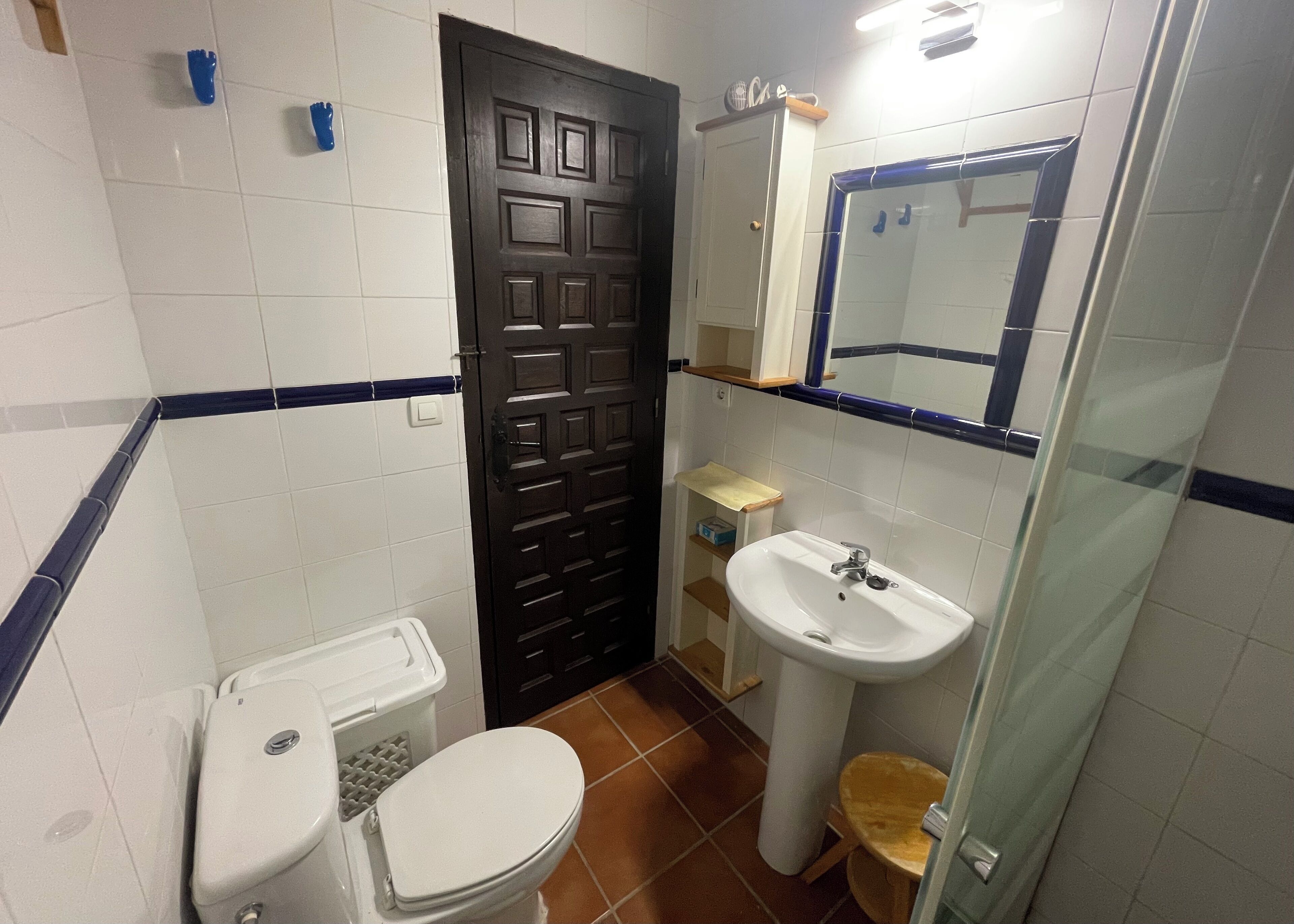 A bathroom with a toilet, sink, and shower.