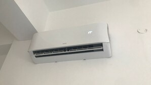 A white Unicell air conditioner mounted on a plain white wall.