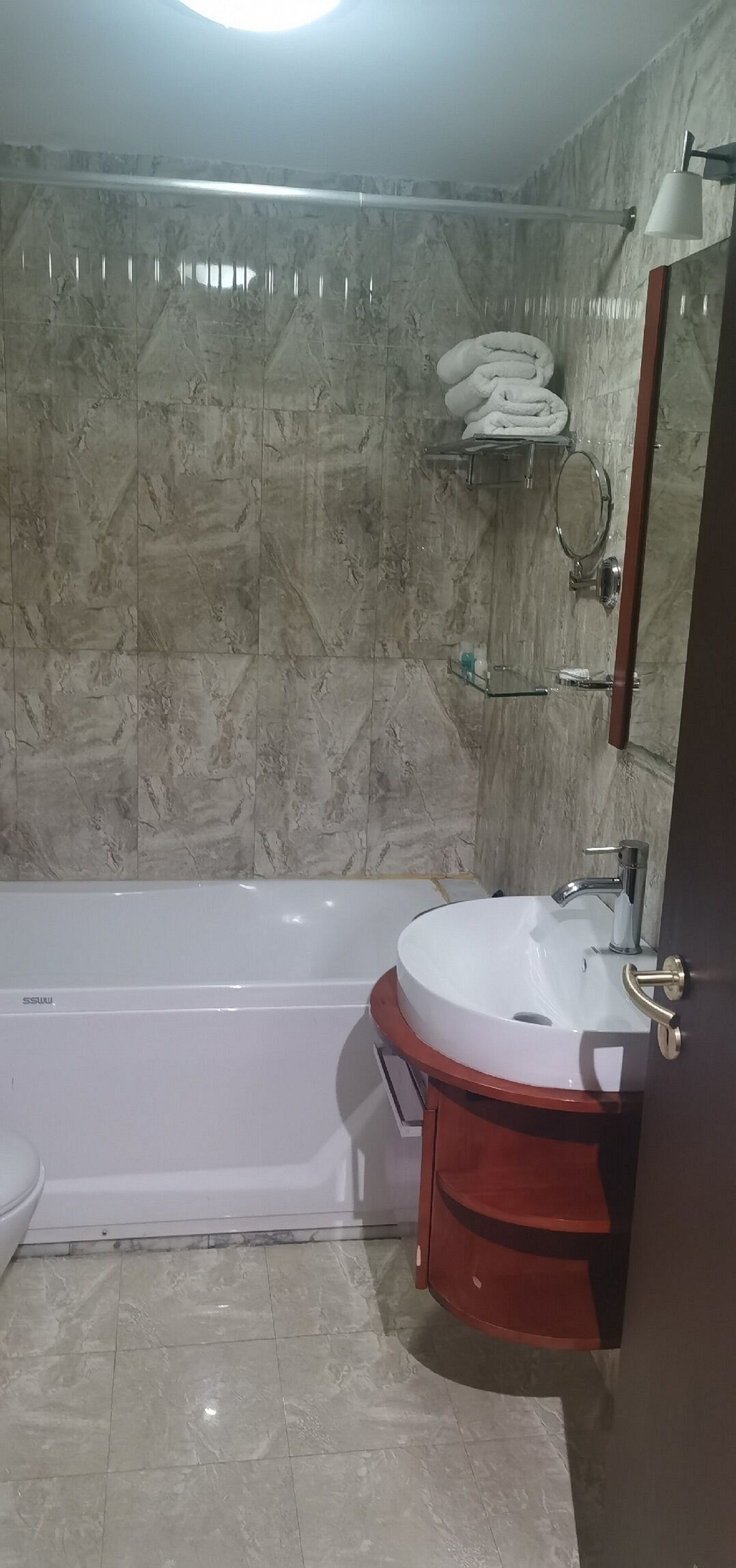 A bathroom with a bathtub, a white sink, and a mirror.