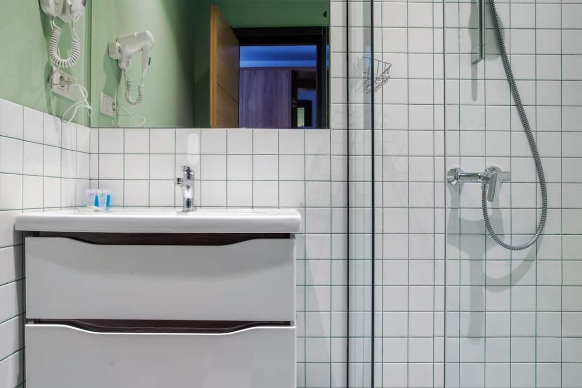 family studio suite | bathroom | shower, hair dryer, slippers, towels