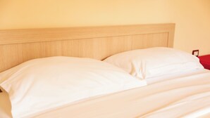 A bed with a wooden headboard and white bedding.