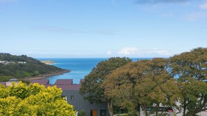 Une vue sur la côte, avec un bâtiment moderne, des arbres et un ciel dégagé.