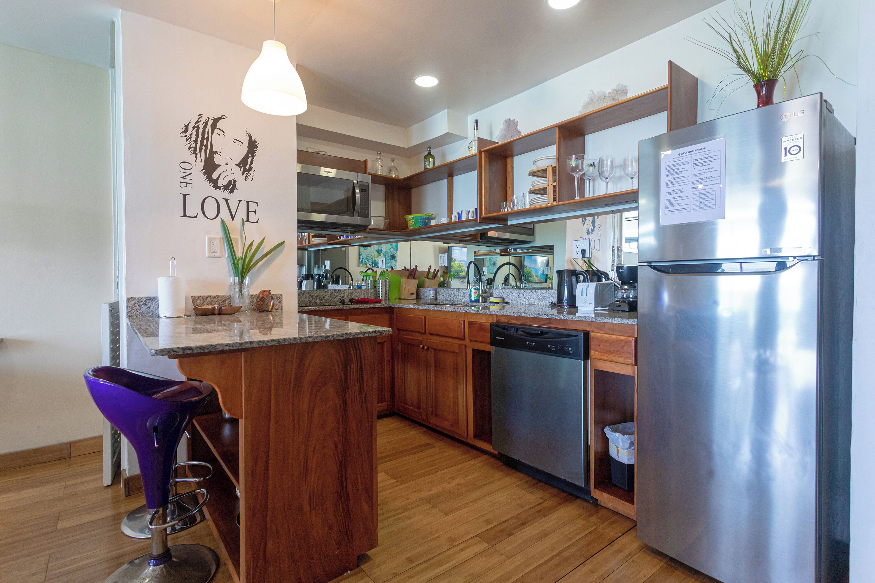A modern kitchen with wooden cabinets, a stainless steel refrigerator, and a built-in microwave.