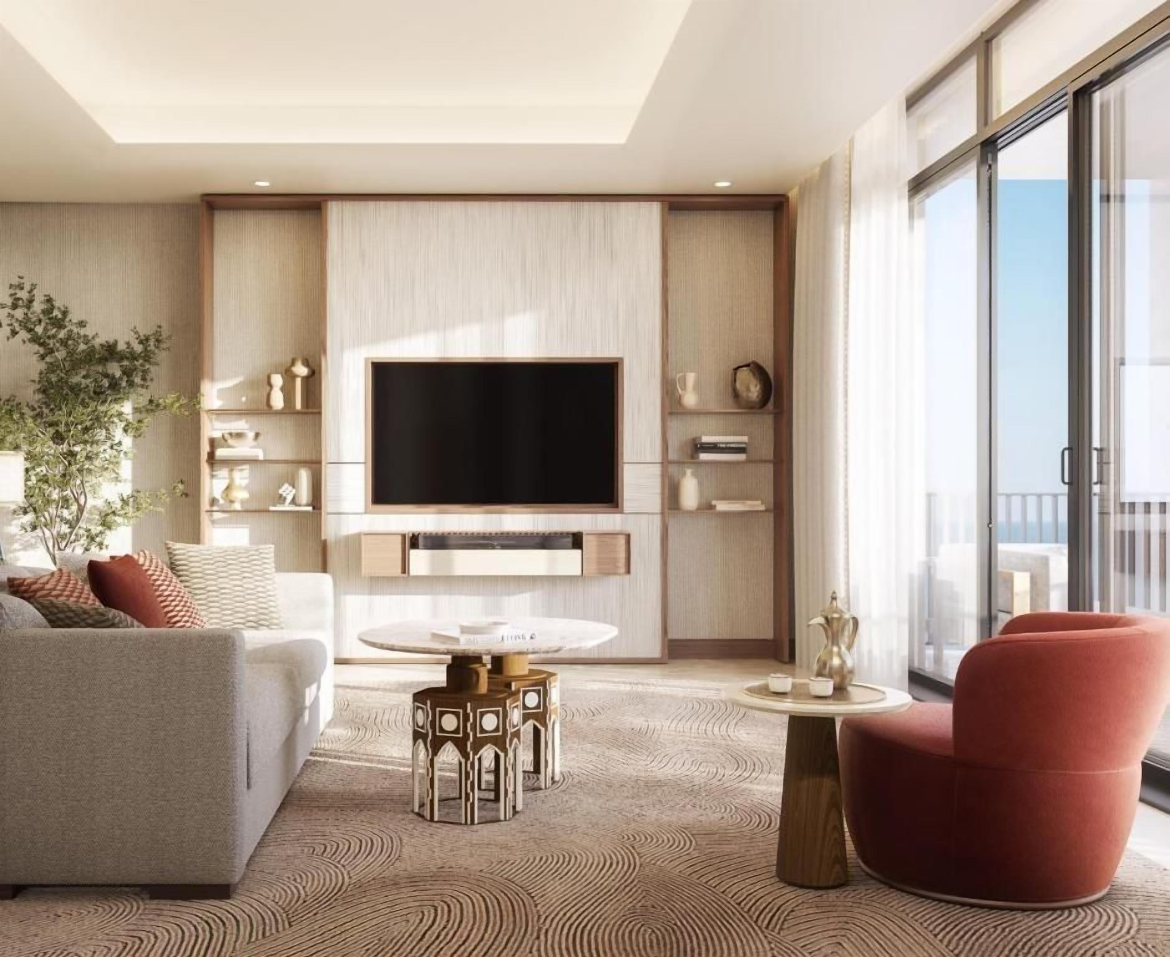 Una sala de estar moderna con un televisor de pantalla plana, un sofá, un sillón rojo y una mesa de centro.