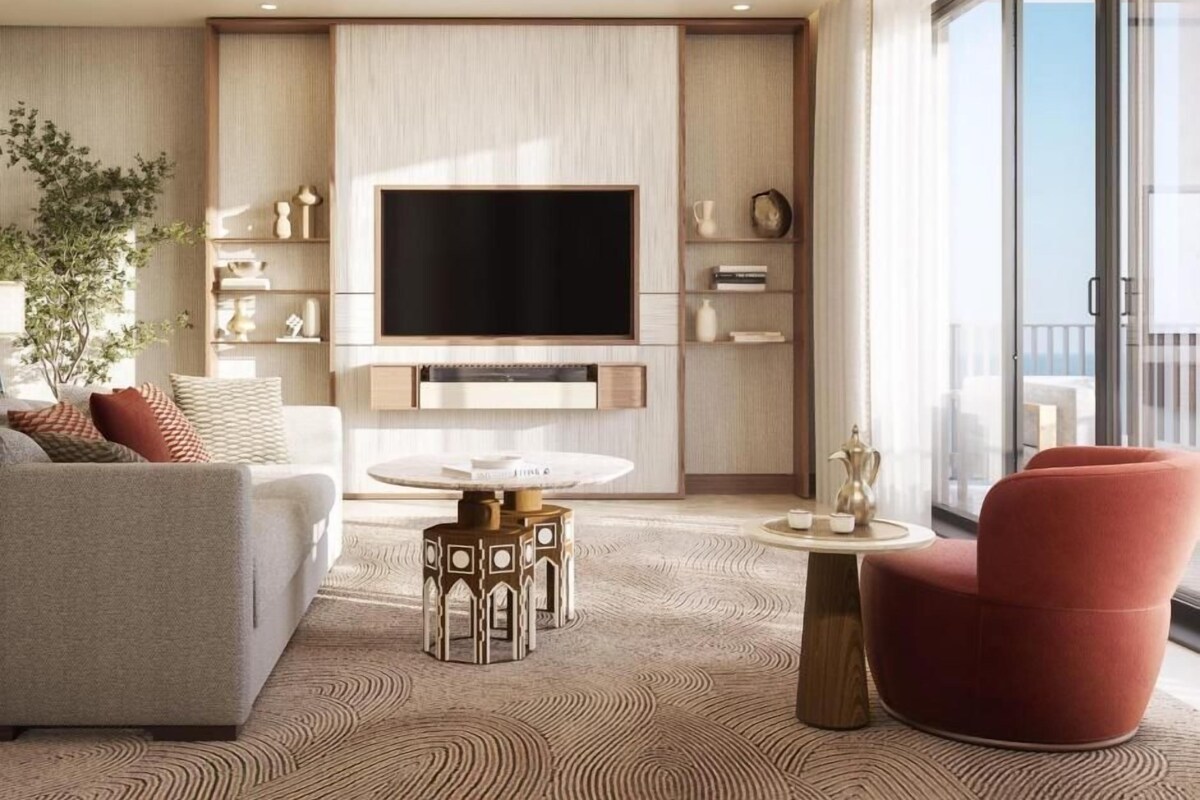 A modern living room with a flat-screen TV, a sofa, a red armchair, and a coffee table.