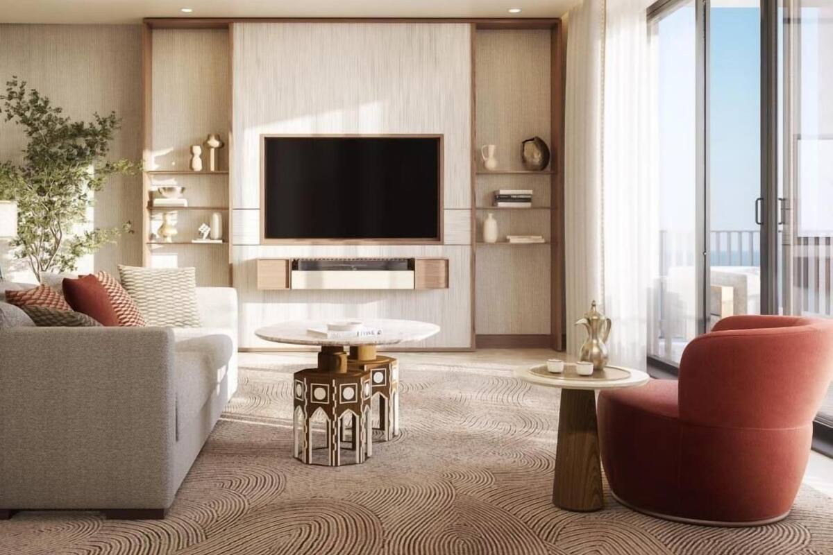 Una sala de estar moderna con un televisor de pantalla plana, un sofá, un sillón rojo y una mesa de centro.
