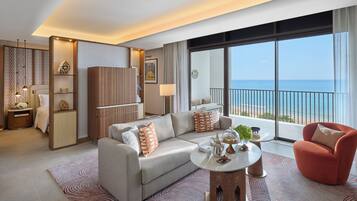 Una habitación de hotel moderna con sofá, sillón y una mesita redonda.