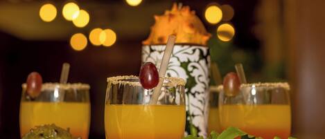 Trois cocktails décorés, un objet décoratif et un arrière-plan flou avec des lumières.