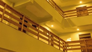 Un interior de varios niveles con barandales de madera e iluminación empotrada.
