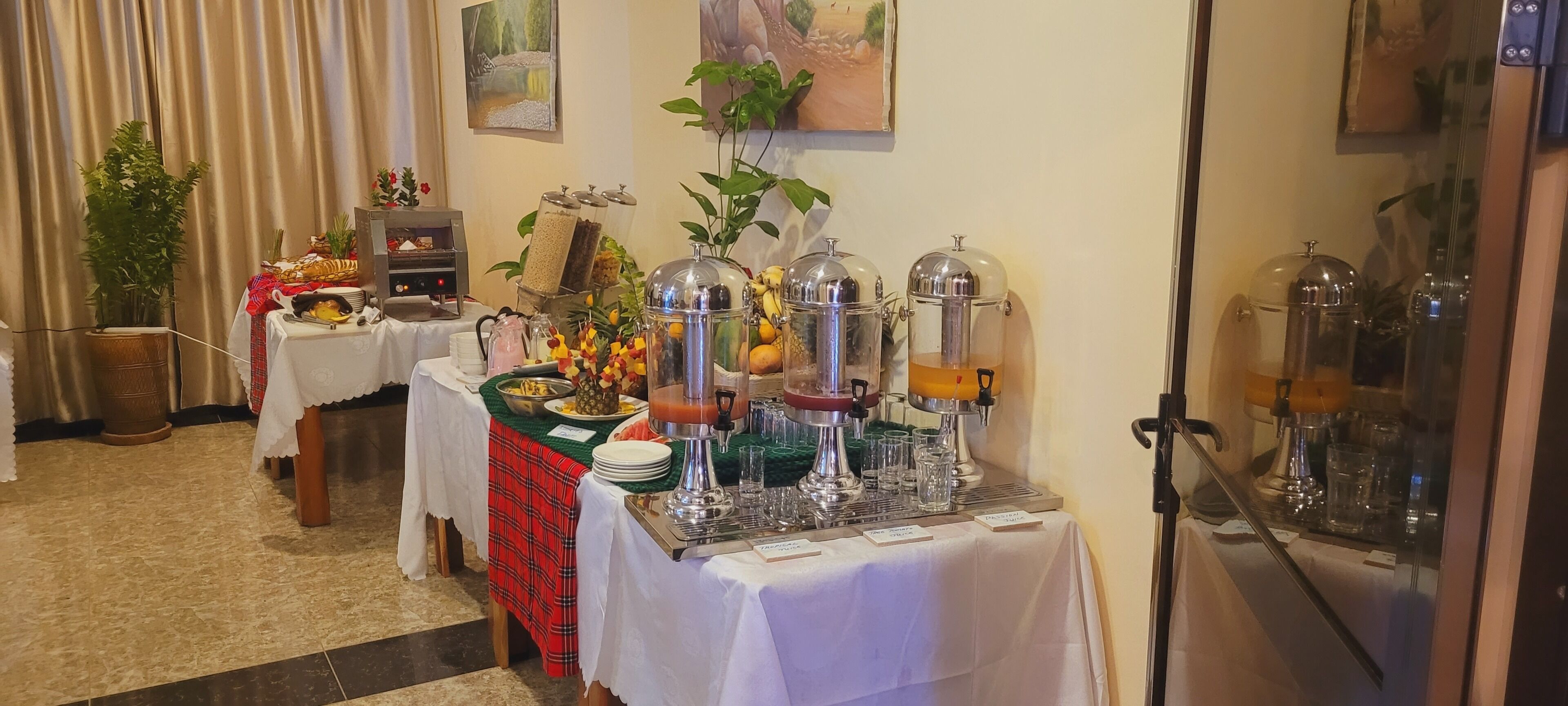En buffé med ett varierat utbud av mat och dryck, inklusive en fruktskål, en sallad och en juiceautomat.