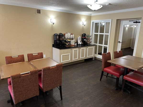 A dining area with a counter, chairs, and tables. - HomeTowne Studios by Red Roof Southfield (Southfield)