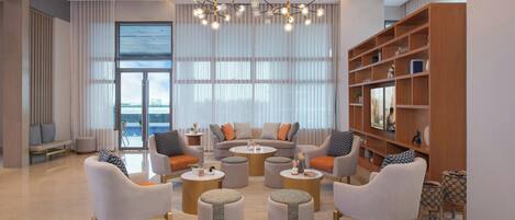 A modern living room with a sofa set, coffee tables, and a bookshelf.
