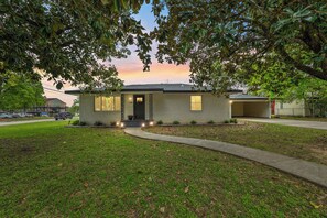 A single-story house with a front porch, a driveway, and a garage.