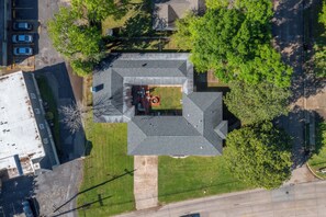 An aerial view of a building with a central courtyard, surrounded by trees and a parking lot. - Luxury Creole Cottage - Sleeps 6 guests (Lafayette)