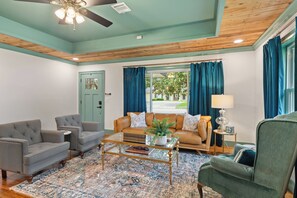 A living room with a sofa, two armchairs, a coffee table, and a lamp.