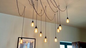 A ceiling with multiple hanging light fixtures and a framed picture on the wall. - Chester Centre 2-bed Apartment -by Oddfellows (Chester)