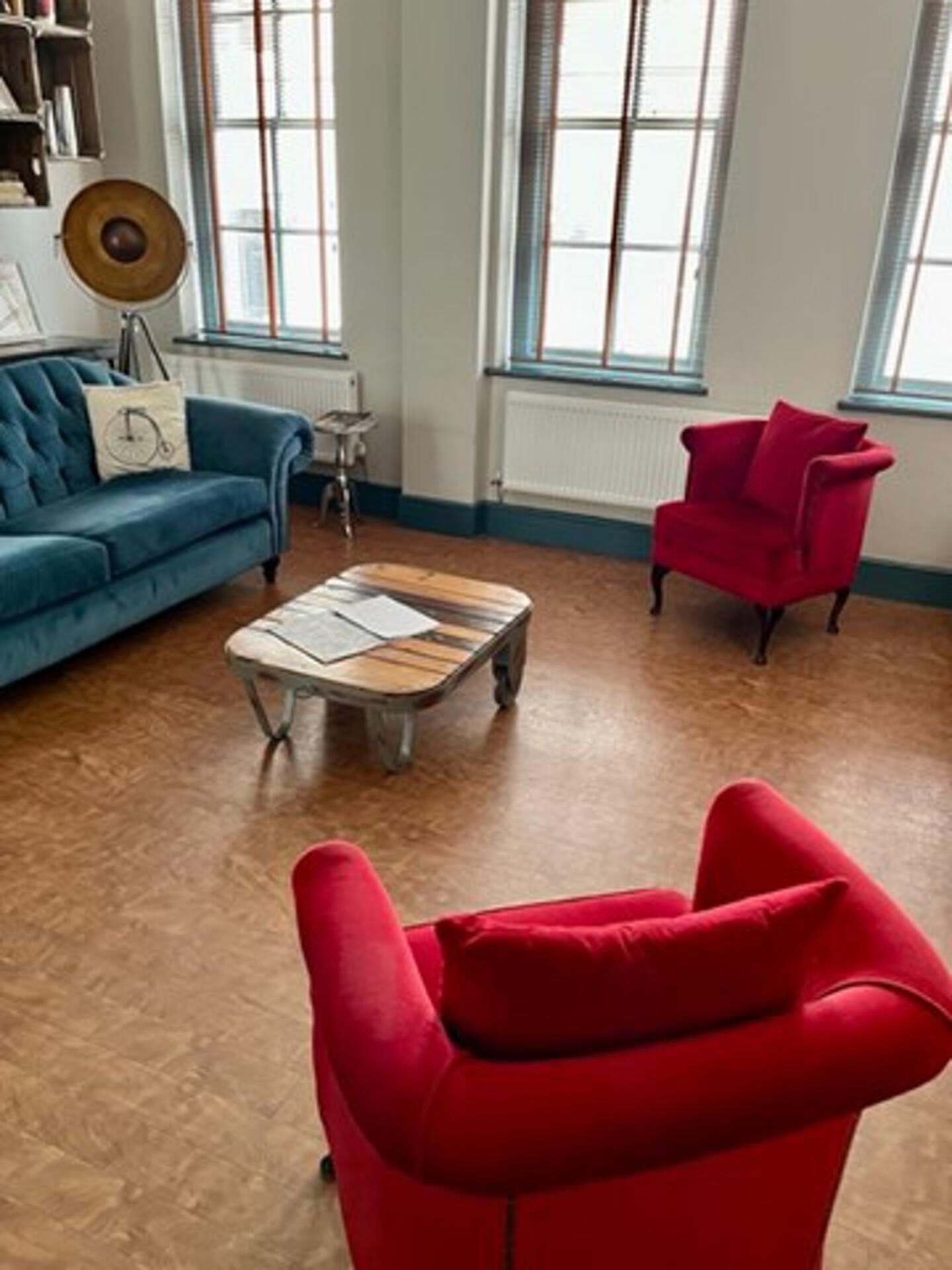 A living room with a blue sofa, a red armchair, and a coffee table.