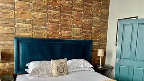 A bed with a blue headboard, white bedding, and a beige throw blanket. - Chester Centre 2-bed Apartment -by Oddfellows (Chester)