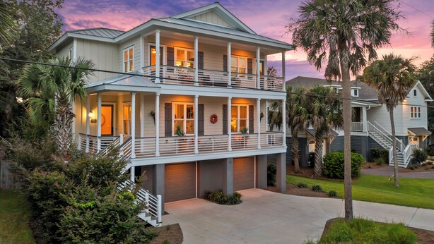 A two-story house with a balcony, a garage, and a well-maintained lawn.