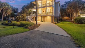 A two-story house with a front entrance, a visible garage, and a well-maintained lawn.