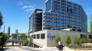 Een Kroger winkel met een modern ontwerp, met een grote glazen gevel en een opvallend Kroger logo op de buitenkant van het gebouw.