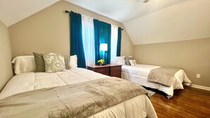 A bedroom with two beds, a nightstand, a dresser, and a lamp. - Super Spacious Safari Retreat.. Lots of SPACE-Deck + Grill,  near Memphis/Desoto (Southaven)