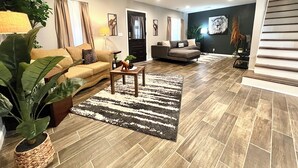 A modern living room with a sofa, a coffee table, and a rug. - Super Spacious Safari Retreat.. Lots of SPACE-Deck + Grill,  near Memphis/Desoto (Southaven)