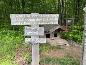 A wooden signpost with warnings about man eating dogs and names of dogs. - Driftwood Treehouse Cabin w/AC, Peaceful & Cozy! (Grandview)