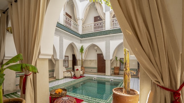 A courtyard with a swimming pool, potted plants, and a tiled floor. - Riad Safran et Soleil (Marrakech)