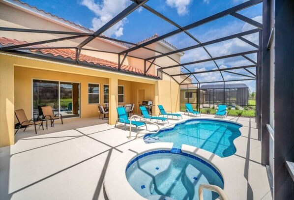Relax by the pool surrounded by lounge chairs and a hot tub.