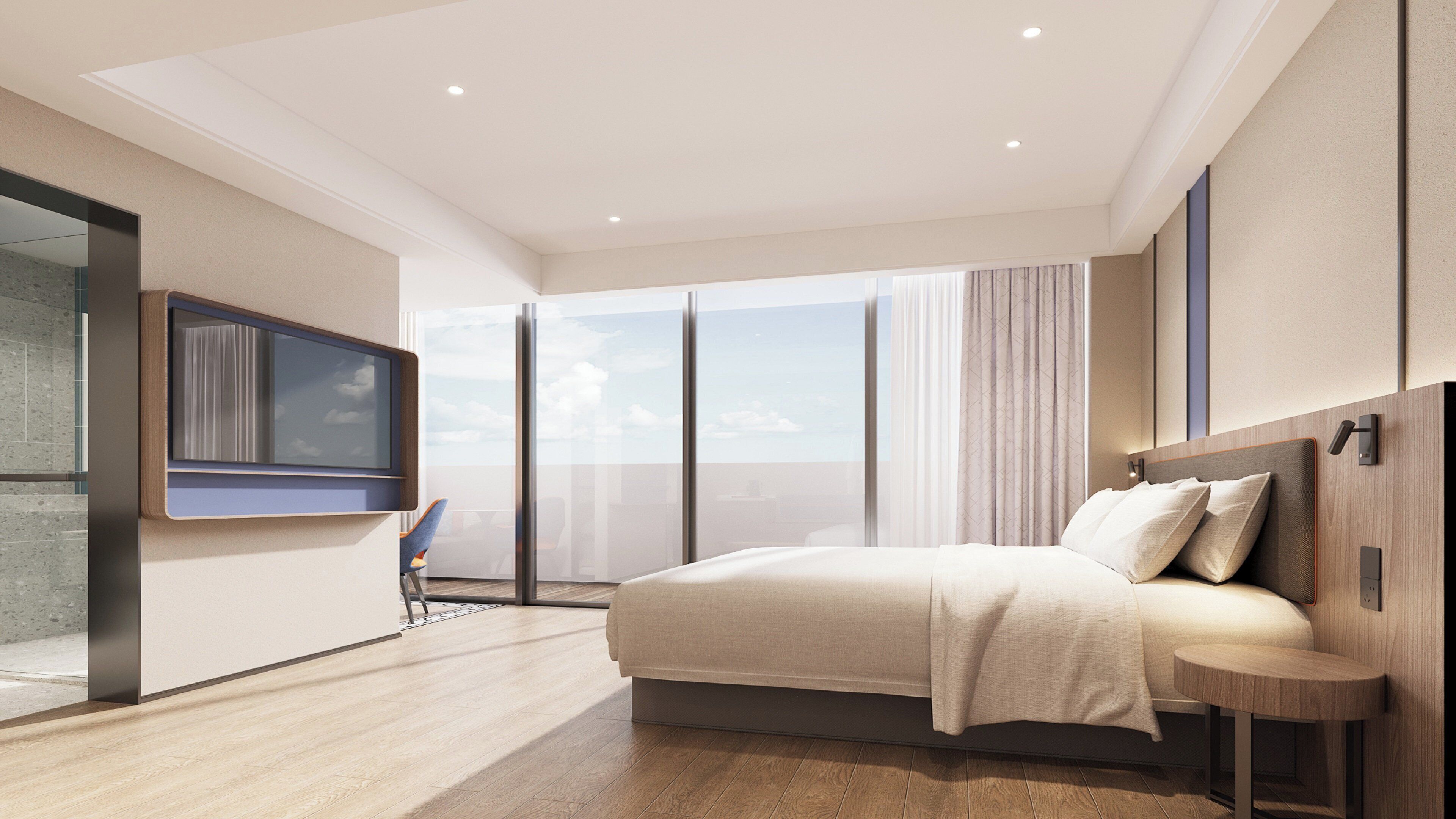 Un dormitorio moderno con una cama grande, un televisor montado en la pared y vistas a la ciudad a través de amplios ventanales.