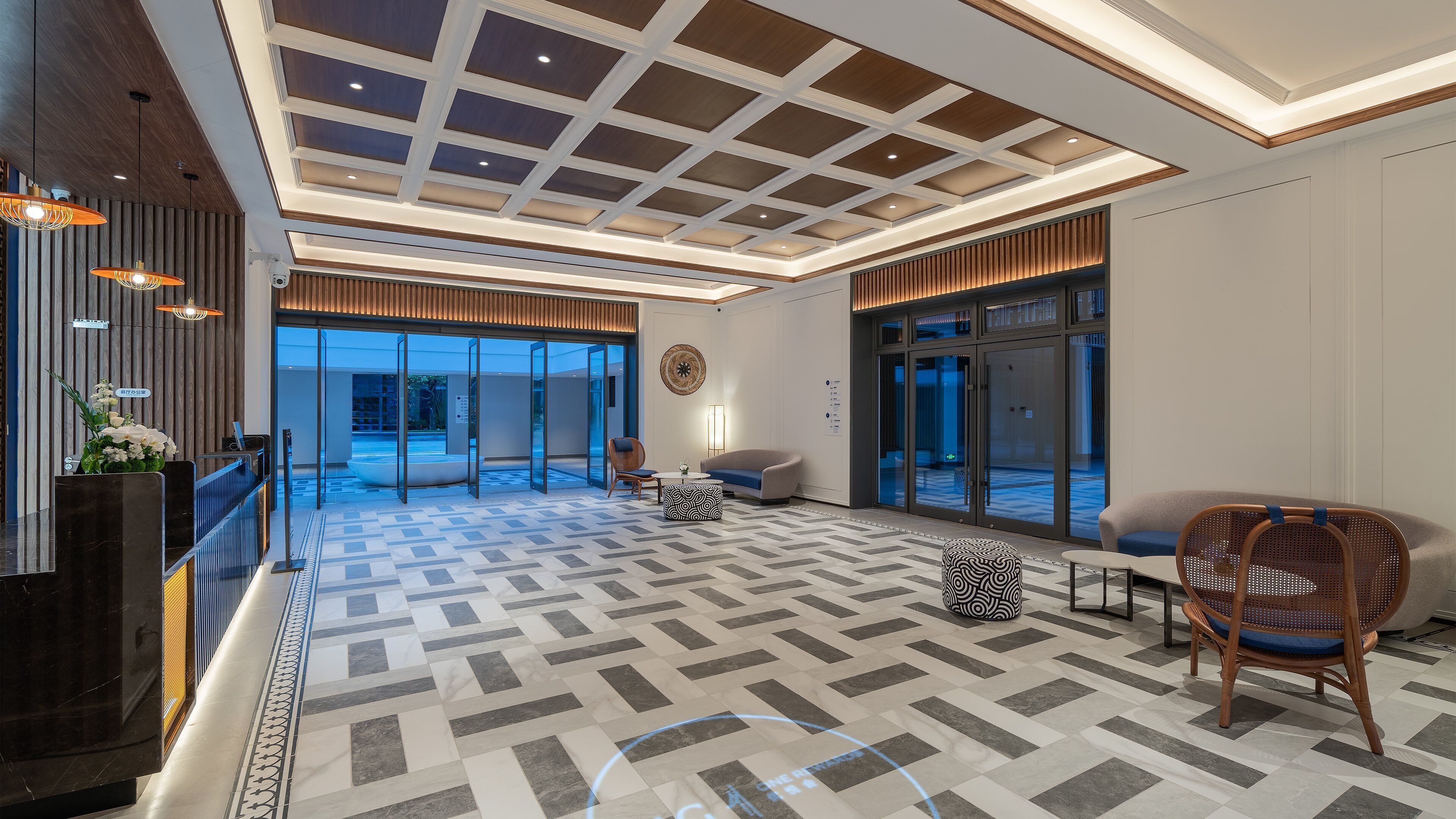 Un hall de hotel con mostrador de recepción, zona de estar y amplias ventanas.