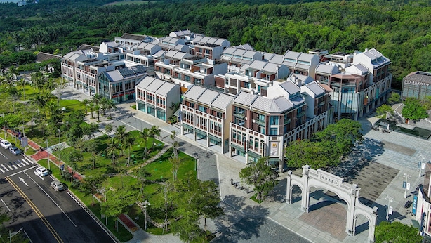 A modern hotel complex with multiple buildings, a central courtyard, and a view of the surrounding forest. - Holiday Inn Express Wenchang by IHG (Wenchang)