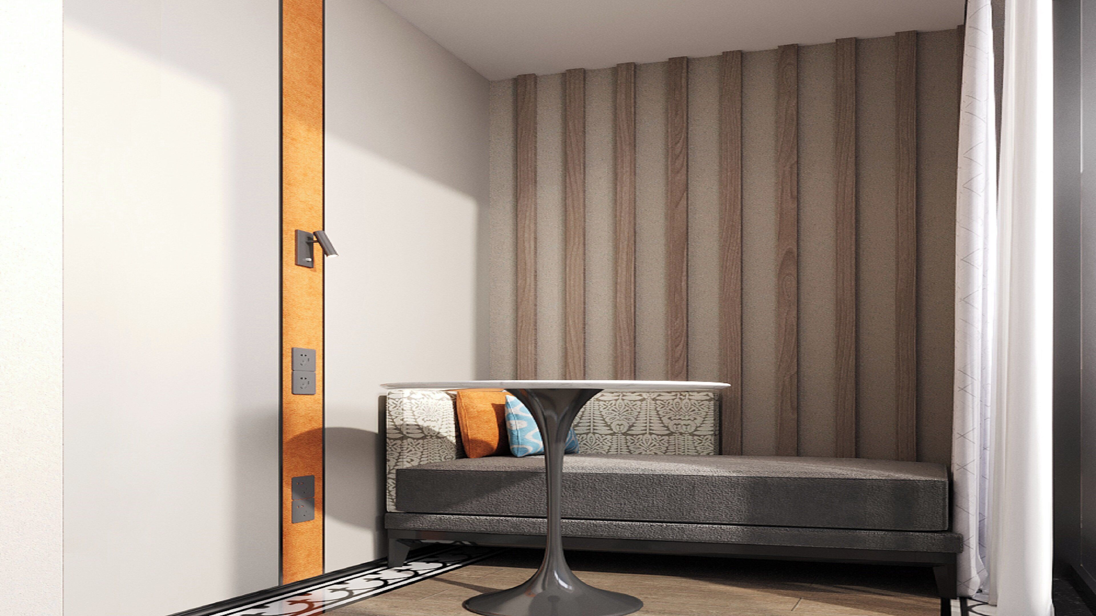 A corner room with a sofa, a small table, and a patterned curtain.
