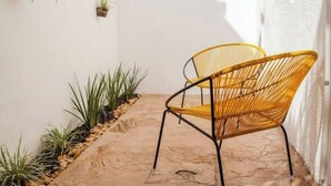 A small patio area with two wicker chairs, a potted plant, and a stone floor. - Premium House 4 BR in Downtown, Walk Everywhere! (Valladolid)