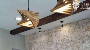 A modern kitchen with a stone backsplash, wooden ceiling beams, and a bar area with white mugs labeled "Casa Tulita". - Premium House 4 BR in Downtown, Walk Everywhere! (Valladolid)