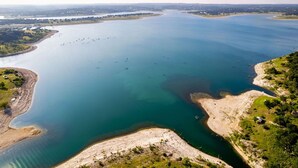 Luftaufnahme eines großen Wassers mit sandigem Strand und spärlicher Vegetation.