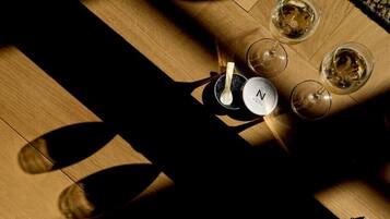 A wooden floor with four glasses of white wine and a bottle with a spoon.