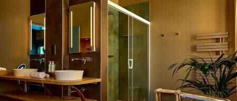 A modern bathroom with a large bathtub, a glass shower enclosure, and a vanity with a mirror.