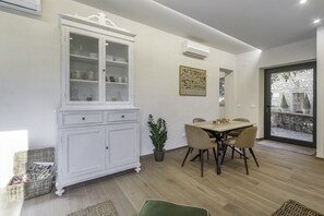 Un comedor con un armario blanco, una mesa, sillas y una planta en maceta.