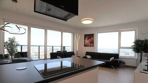 Una cocina moderna con una isla grande, ventanas amplias y vistas a la ciudad.